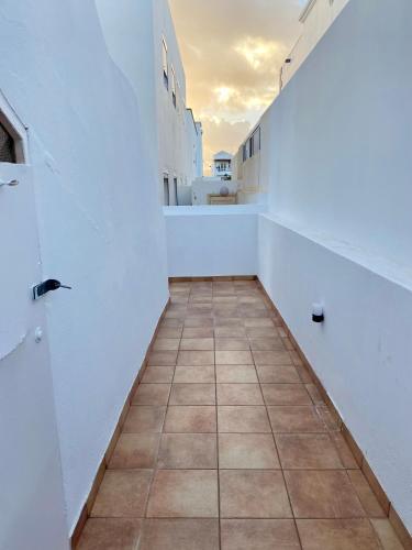 an empty hallway with a tile floor and white walls at Playa Honda Red Suite in Playa Honda