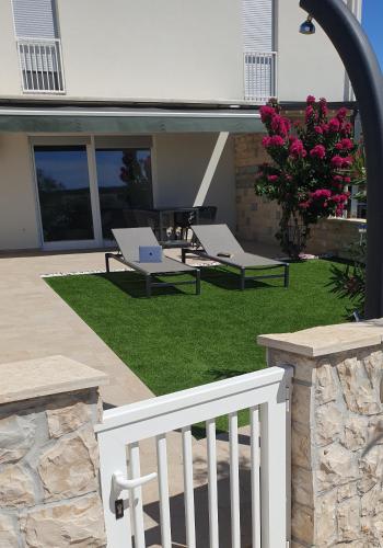 a patio with two lounge chairs and a table at Beachfront deluxe apartment in Povljana