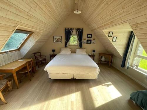 a bedroom with a large bed in a attic at Villa, piscine 3 ha 12à15 personnes in Crach