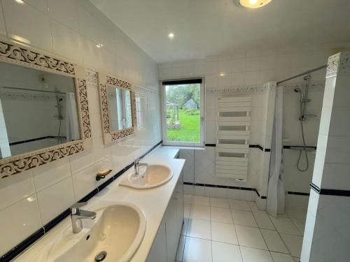 a white bathroom with two sinks and a shower at Villa, piscine 3 ha 12à15 personnes in Crach