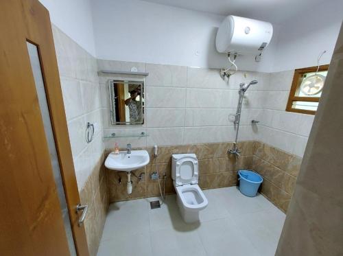 a bathroom with a toilet and a sink at Shri Sai Baba Homestay - EB Colony - Trichy in Tiruchchirāppalli