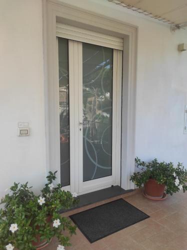 a glass door on a house with two potted plants at Sunset House in Massa Lubrense
