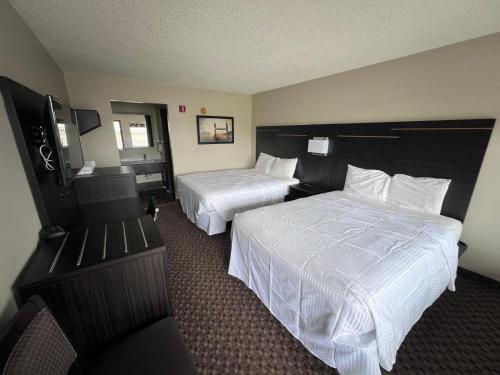 a hotel room with two beds and a television at Country Nights Inn in West Union