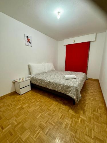 a bedroom with a bed and a wooden floor at La Maison de Voyage in Lausanne