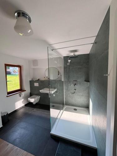 a bathroom with a glass shower and a sink at s´Bergnestle in Bad Hindelang