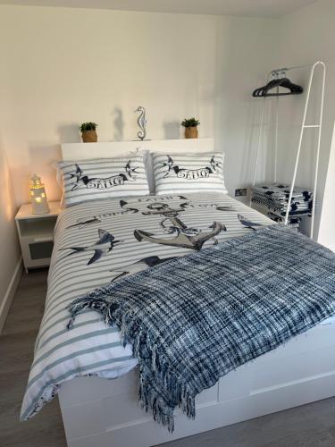 a white bed with a blanket on top of it at The Garden Room in Torquay