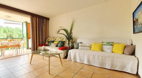a living room with a couch and a table at Appartement T2 lumineux, confortable et spacieux à Saint-Anne proche plage de l'Anse Caritan in Sainte-Anne