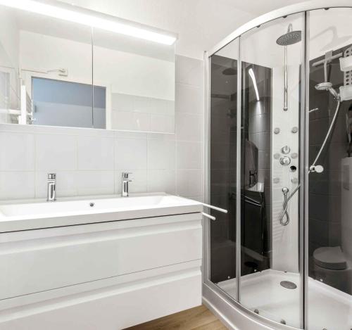 コクセッドにあるCadiz penthouse - uniek 5 sterren appartement met grote terrassen en fantastisch zeezichtの洗面台とシャワー付きの白いバスルーム