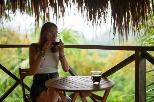 a woman sitting at a table taking a picture at The Journey Hostel in Los Naranjos