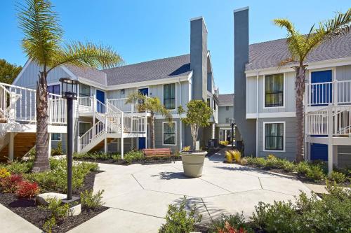 a large house with palm trees and a courtyard at Residence Inn Los Angeles LAX/Manhattan Beach in Manhattan Beach