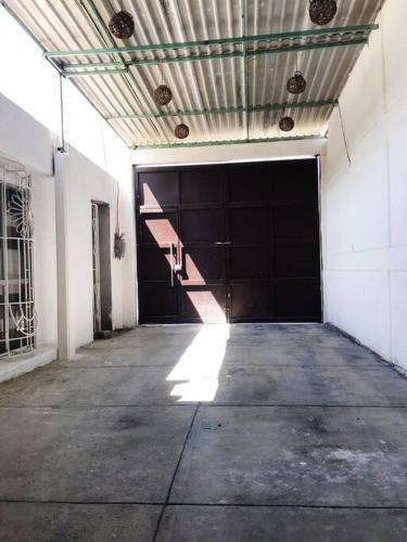 an empty garage with a large black garage door at Estancia inteligente in Mexico City