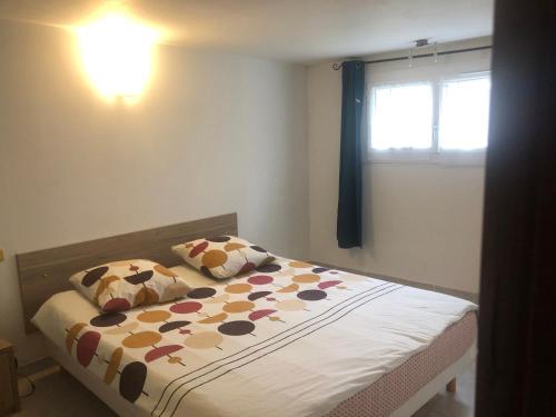 - une chambre avec un lit avec deux oreillers et une fenêtre dans l'établissement Appartement donnant sur jardin avec terrasse., à La Roche-sur-Yon