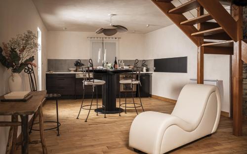 Una cocina con una mesa y sillas en una habitación. en Superbe appartement loveroom avec balnéo Dolce notte, en Carbonne