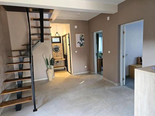 a living room with a spiral staircase in a house at Très belle villa avec piscine in Foulpointe