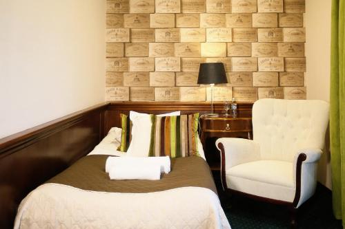 a hotel room with a bed and a chair at Hotel Imperium in Chełmża