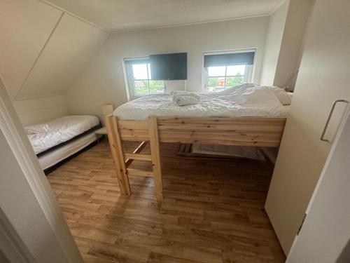 a small bedroom with a bed and a window at Watervilla met prachtig uitzicht in Stavoren