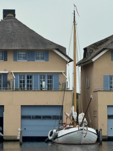 a sailboat is docked in front of a house at Watervilla met prachtig uitzicht in Stavoren