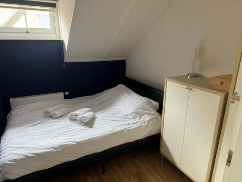 a small bedroom with a bed with towels on it at Watervilla met prachtig uitzicht in Stavoren