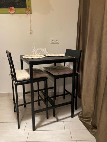 a black table with two chairs and a table at Petit studio aux portes du beaujolais in Saint-Germain-Nuelles
