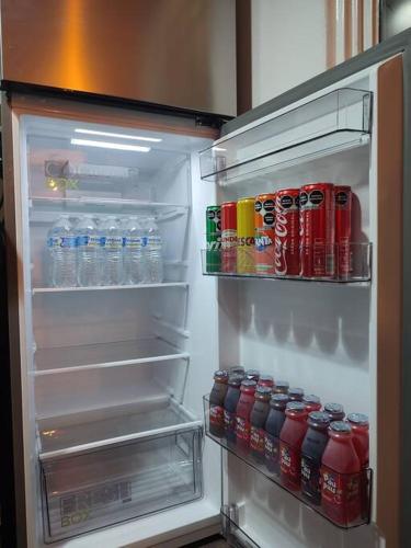 an open refrigerator filled with drinks and soda cans at Escondite Artesanal Mex in San Francisco Cuautliquixco