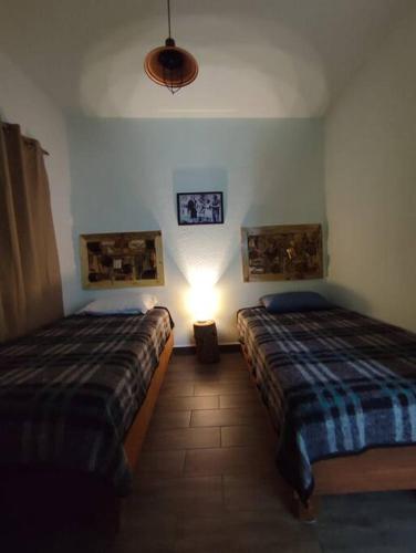a bedroom with two beds and a light on the wall at Escondite Artesanal Mex in San Francisco Cuautliquixco