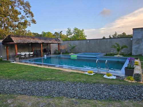 a swimming pool in a yard with a gazebo at Très belle villa avec piscine in Foulpointe