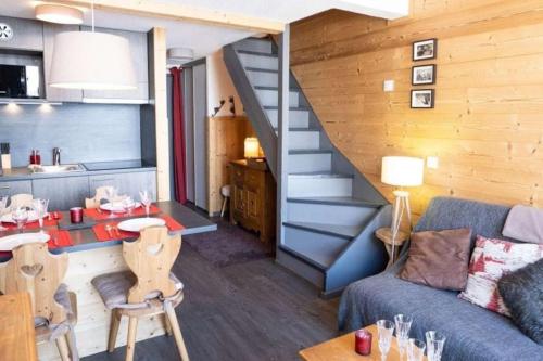 - un salon avec un canapé bleu et un escalier dans l'établissement Appartement duplex-mezzanine, à Val Thorens
