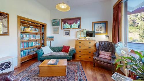 a living room with a couch and a chair at Bluff Hill Lighthouse B&B in Napier