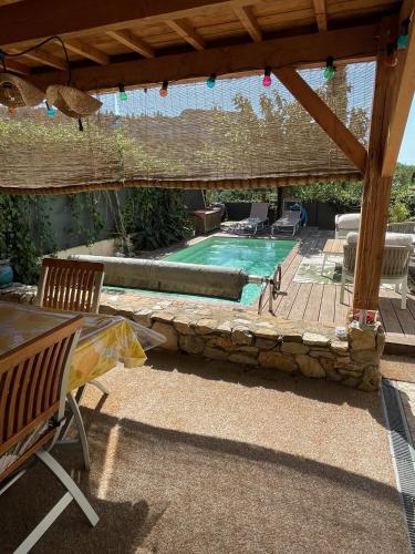 une cour avec une piscine et une pergola en bois dans l'établissement Agapi Mou, aux Baux-de-Provence