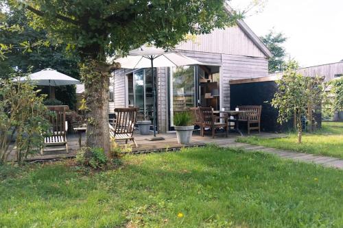 a patio with a table and chairs and an umbrella at Vakantiewoning MV8 in Egmond-Binnen