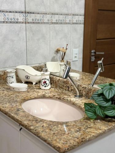 a bathroom counter with a sink and a mirror at Apartamento aconchegante no centro in Ariquemes