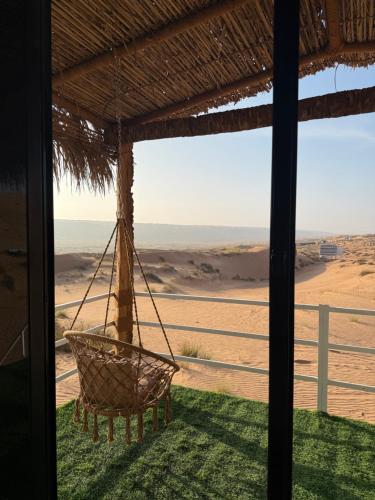 a hammock hanging from a porch with a view of the desert at Royal desert camp in Al Raka