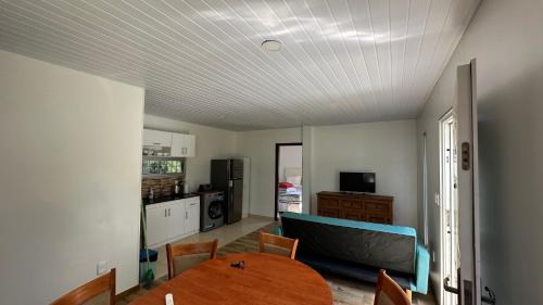 a living room with a table and a kitchen at Casa excelente ubicación en Atlántida Sur in Atlántida