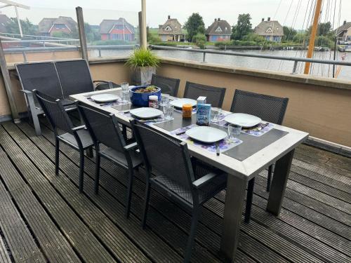 a table on a balcony with a table and chairs at Watervilla met prachtig uitzicht in Stavoren