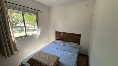 a small bedroom with a bed with a window at Casa excelente ubicación en Atlántida Sur in Atlántida