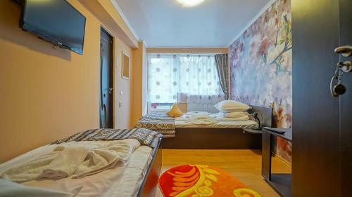 a small room with two beds and a tv at Vila Muntii Bucegi & SPA in Bran