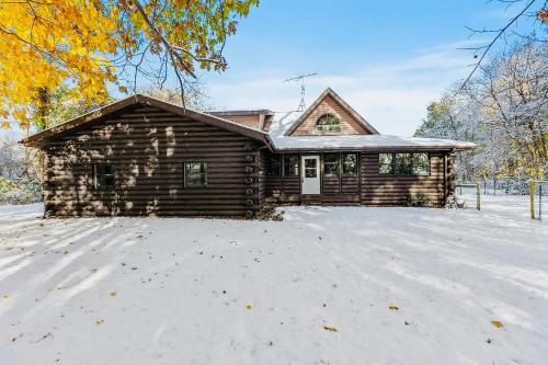a log cabin with snow in front of it at Serene Log Cabin Forest Retreat in LaPorte