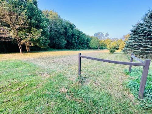 a wooden fence in the middle of a field at Serene Log Cabin Forest Retreat in LaPorte