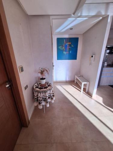a room with a table with a potted plant on it at Appartement piscine front de mer in Mohammedia