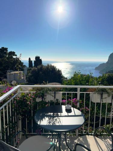 a balcony with a table and a view of the ocean at La Reginella Capri in Capri