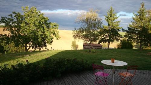 a table and chairs on a patio with a field at La Grande Oasis - B&B et Spa in Grazac