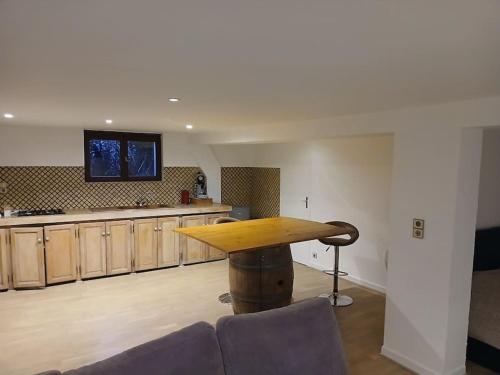 Il comprend un salon avec une table en bois et une cuisine. dans l'établissement Loft spacieux et cosy, à Toulouse