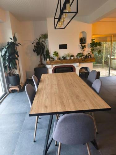 a dining room with a wooden table and chairs at Maison de Charme à la campagne in Plumaugat
