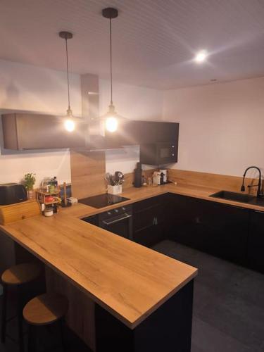 a kitchen with a wooden counter top and a sink at Maison de Charme à la campagne in Plumaugat