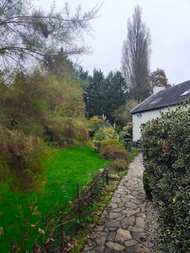 a stone path leading to a house in a garden at Maison de Charme à la campagne in Plumaugat
