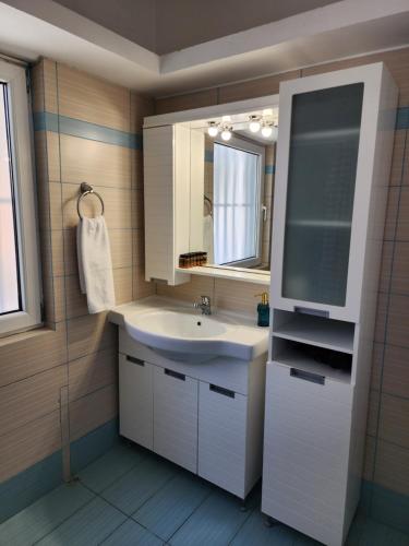 a bathroom with a sink and a mirror at Villa Nikolitsa with private beach in Megara