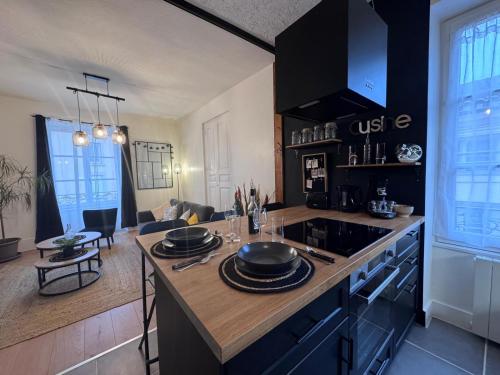 Il comprend une cuisine équipée d'une cuisinière. - un four supérieur à côté d'un salon dans l'établissement Le Châtillon T3 Vue sur Saône Centre Mâcon, à Mâcon