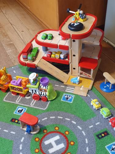 a toy house with toys on the floor at Bed n Bureau Roggwil in Roggwil