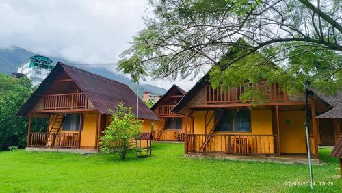 a yellow house with a green lawn in front of it at Ecolodge Don Felix in Quillabamba