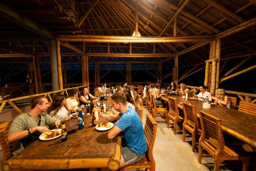 a group of people sitting at tables in a restaurant at The Journey Hostel in Los Naranjos